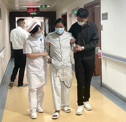 术后，护理人员与家属帮助达瓦母亲下床活动